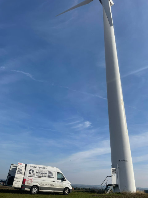 LeoTus Servicewagen vor einem Windkraftrad